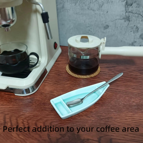 Boat Shaped Coffee Spoon Rest With Turquoise Accent And Matching Mini Spoon beside coffee maker on counter