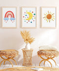 Wall with three framed rainbow, moon, and sun boho patterns from Five Piece Starter Embroidery Kit For Beginners With Boho Cross Stitch Patterns.