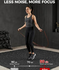 Person jumping rope on Interlocking Gym Floor Tiles 0.56 Inch Thick, 24 By 24 Inch, 12 Piece Set, EVA Foam Exercise Mats, Black and White.