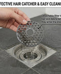Heavy Duty 2 Inch Shower Floor Drain Stopper With Magnetic Backflow Preventer And Flexible Silicone Seals To Kick Those Funky Sewer Smells To The Curb And Keep Your Basement Floor Dry, showing a hand holding a hair-catching filter.