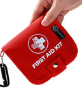 Hand holding Mini First Aid Kit For Home Car Travel And Outdoor Adventures 137 Piece Emergency Medical Kit Lightweight Compact With Carabiner