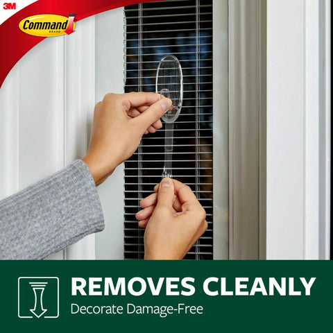 Person mounting Clear Large Hook Set Of Four For Damage Free Hanging Includes Eight Large Strips Each Hook Holds Up To Four Pounds