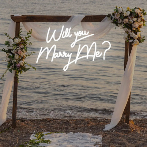 Beach setting with floral arch and 'Will You Marry Me?' neon sign, Marry Me Neon Sign Lights for Engagement Party and Wedding Decor