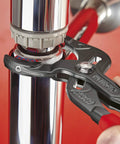 Go-To Siphon And Connector Pliers 9.84 In With Plastic Jaws, 25-Position Adjustment, gripping a pipe fitting.