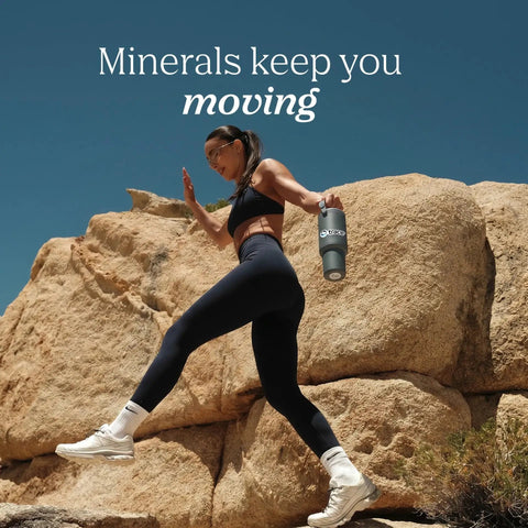 Woman climbing rocky terrain holding a water bottle featuring Straight Up Liquid Trace Mineral Drops Loaded With Seventy Plus Ionic Minerals And Key Electrolytes Like Magnesium Potassium And Chloride For Prime Body Function And Real Daily Vitality.