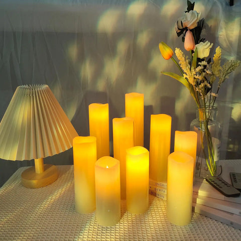 Flameless Battery Operated LED Pillar Candles Set Of Nine With Remote And 24 Hour Timer Ivory Real Wax Look on table