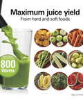 Front view of black juicer machine with 3in feed chute and 800W centrifugal extractor, pouring green juice into glass