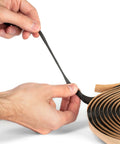 Hands pulling Durable Pro Grade Butyl Sealant Tape For Auto RV Marine And Window Glazing One Roll Twenty Feet By One Half Inch