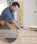Premium Acrylic Letter And Number Router Templates Pack Of Six Hella Durable Woodcarving Stencils With Punctuation Marks Totally Legit For Any Diy Project Or Custom Engraving Job Measuring Roughly 7By2 Inches on a workbench.