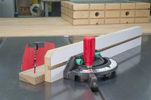 Woodworking jig with miter gauge and red handle on table saw for precise cutting