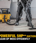 Person using 9 Gallon Wet Dry Shop Vacuum With 5 Peak HP Motor, Poly Can, Rubberized Casters, 10 Foot Cord, And 3 In 1 Multi Function on construction debris