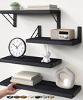 Straight Up Sleek Wall Mounted Floating Shelves In Matte Black Solid Set Of Four with decorative items and clock.