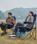Two Pack Oversized Folding Camping Chair Set With High Back Padded Comfort Grab And Go Style Lightweight Steel Frame Portable Lawn Chairs For Outdoor Use Easy Fold Sturdy And Durable For Adults Grey in use by couple by a lakeside.