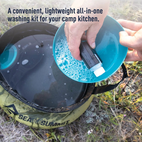 Hands washing a dish with soap over a 10L collapsible sink from You Gotta Have Camp Kitchen Cleanup Kit 6 Piece Set