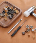 Straight Up Game Changer Bottom Guards Include 24 Assorted Handbag Feet with screws and tools laid out on leather.