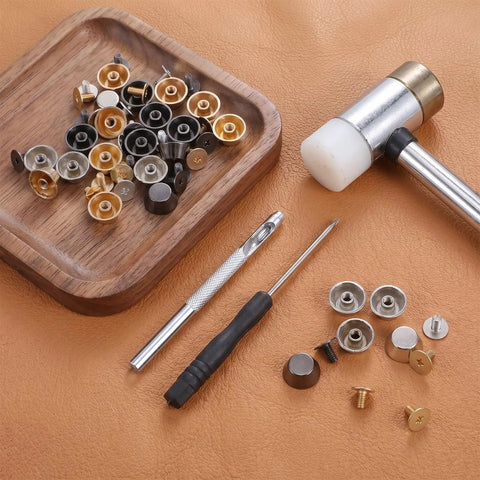 Straight Up Game Changer Bottom Guards Include 24 Assorted Handbag Feet with screws and tools laid out on leather.