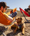 Two people relaxing and a dog near Portable Hammock Stand 15 Lb Lightweight With Quick Setup And Chair Mode Carry Bag And Straps