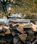 Komplete NCR N2 Powered.22 Caliber PCP Air Rifle with disposable nitrogen cartridges on wood pile