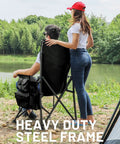Two people by a lake using Oversized Folding Camping Chair With High Back Support 500 Lbs Capacity Extra Wide Seat.