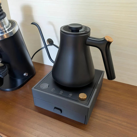 Game Changing Two In One Coffee Station Organizer With Heavy Duty Kettle Stand And V60 Paper Filter Bin For Smooth Pour Over Brewing Rig And Clean Counter Hacks showing matte black kettle on an electric stand.