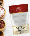 Citric acid 2 lb bag by Spicy World, red top, clear lower panel with white granular crystals.