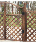 Two black torque-damping hinges mounted on a wooden lattice garden gate