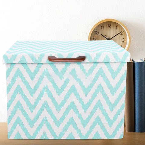 Patterned storage box with zigzag design and wooden handle, placed on a desk with a clock in the background.