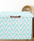 Chevron-patterned storage box with a wooden handle on a shelf, next to books and a round clock.