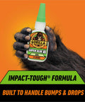 Rock Solid Super Glue Gel No Drip Formula For Precision Repairs And Vertical Fixes Quick Setting Anti Clog Bottle Clear Adhesive Heavy Duty Bonding Pack Of Two held by a furry hand, 25 grams.