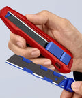 CutiX Universal Snap Knife With Stabilization Bar, 6-1/2 Inch Red Blue Grip in hand, showcasing quick blade change