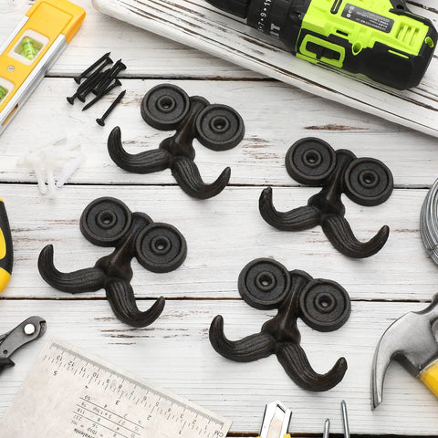 Heckin Durable Four Piece Cast Iron Beard Wall Hooks For Old School Farmhouse Charm And Dang Tough Rustic Decor Hanging Rack For Coats Scarves Towels Keys With Mounting Hardware Included on a wooden surface.