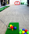 Indoor golf setup with Portable Indoor Golf Chipping Net With Hitting Mat For Backyard Practice and colorful foam balls on mat.