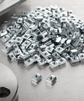 Hella Durable M5 Sliding T Nuts Bulk Pack For 20x20 Aluminum Extrusion Profiles, zinc plated nuts arranged on a surface.