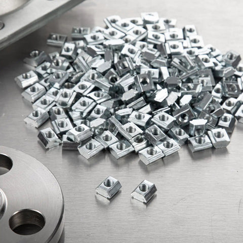 Hella Durable M5 Sliding T Nuts Bulk Pack For 20x20 Aluminum Extrusion Profiles, zinc plated nuts arranged on a surface.