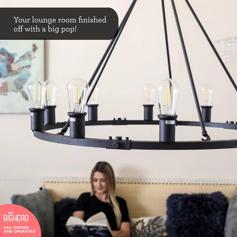 Dope Large Wagon Wheel Chandelier With Ten Lights In Black Rustic Farmhouse Pendant Lighting Hanging Over a Living Room Sofa