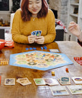 Premium Island Settlement Building Strategy Board Game For Families And Crew Ages 10 Plus Master Resource Trading Expand Territories For An Epic Hella Fun Tabletop Adventure on a wooden table with players and cards.