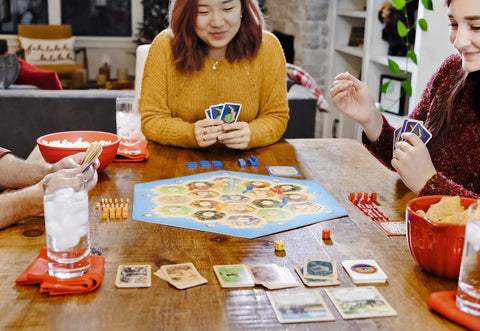 Premium Island Settlement Building Strategy Board Game For Families And Crew Ages 10 Plus Master Resource Trading Expand Territories For An Epic Hella Fun Tabletop Adventure on a wooden table with players and cards.