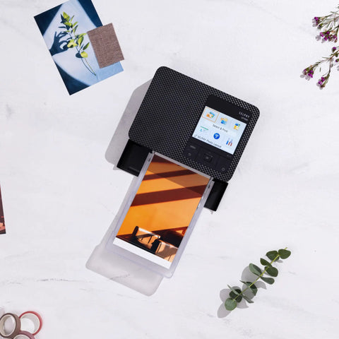 Selphy CP1500 Wireless Photo Printer in black printing a 4x6 photo, showcasing ultra portable design with WiFi and smartphone connectivity.