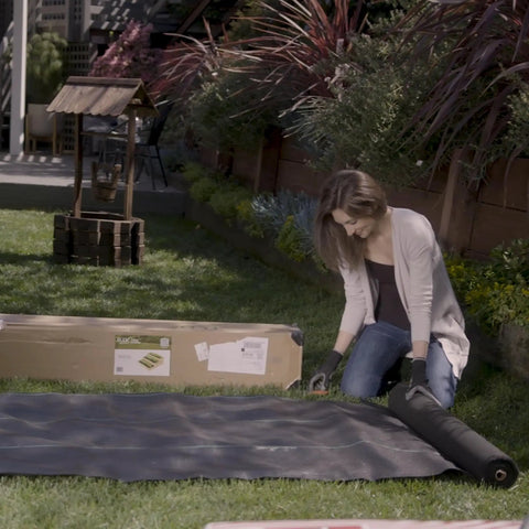 Person installing Pro Grade 5oz Landscape Fabric Weed Barrier Mat 3 Feet By 50 Feet Heavy Duty Ground Cover in garden
