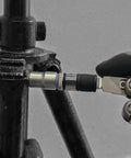 Close-up of Flat End 1 Quarter Inch Hex To Square Socket 2 In 1 Extension Bit Driver attached to multitool on black equipment.