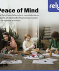 Children playing indoors next to a Rely Essentials carbon monoxide alarm on the wall, highlighting accuracy and peace of mind.
