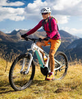 Cyclist riding a mountain bike on a scenic trail in sunny weather