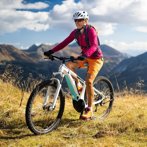 Cyclist riding a mountain bike on a scenic trail in sunny weather