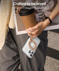 Premium Top Grain Leather MagSafe Phone Grip Holder With Beefy Metal Kickstand And Hella Strong Magnets For No Sweat Daily Carry And Smooth One Handed Control Anywhere, held with coffee and a magazine.