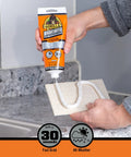Person applying Heavy Duty Construction Adhesive White Glue 7 Ounce Squeeze Tube Pack Of 2 With Fast Grab In 30 Seconds Waterproof Gap Filling Paintable Bond on tile.