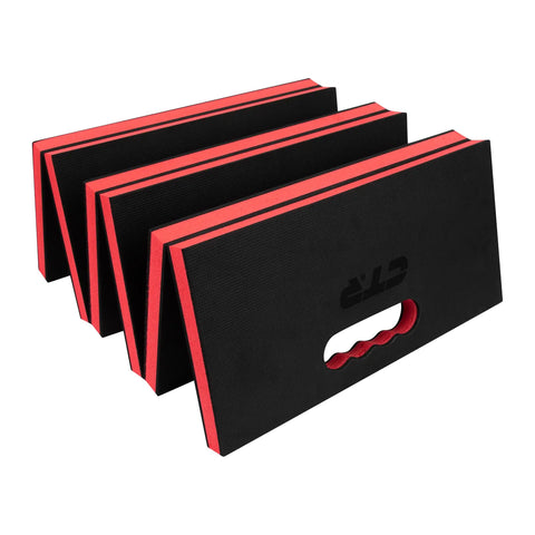 Black and red Mechanic Kneeling Pad Folding Mat For Under Car Work with carry handle, folded view.