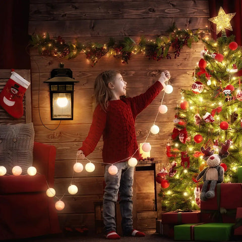 Child decorating Christmas tree near dusk to dawn outdoor light with GFCI outlet and dual receptacles, cozy room setting