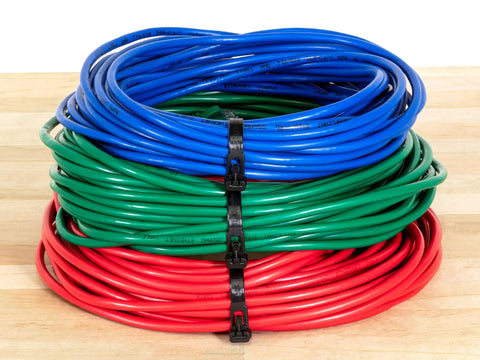 Heavy Duty Reusable Cable Zip Ties Set securing coiled blue, green, and red wires on a wooden surface.