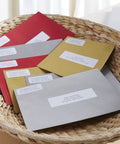No Sweat White Mailing Address Labels For Slick Office Packing on colorful envelopes in woven basket for shipping organization.