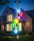 Solar Wind Chimes Outdoor Decor With Hot Air Balloon Lights Waterproof Garden Patio Lighting Lit At Night Perfect Gift For Mothers Day Mom Grandma Birthday showcasing multicolored balloons in front of a modern house at night